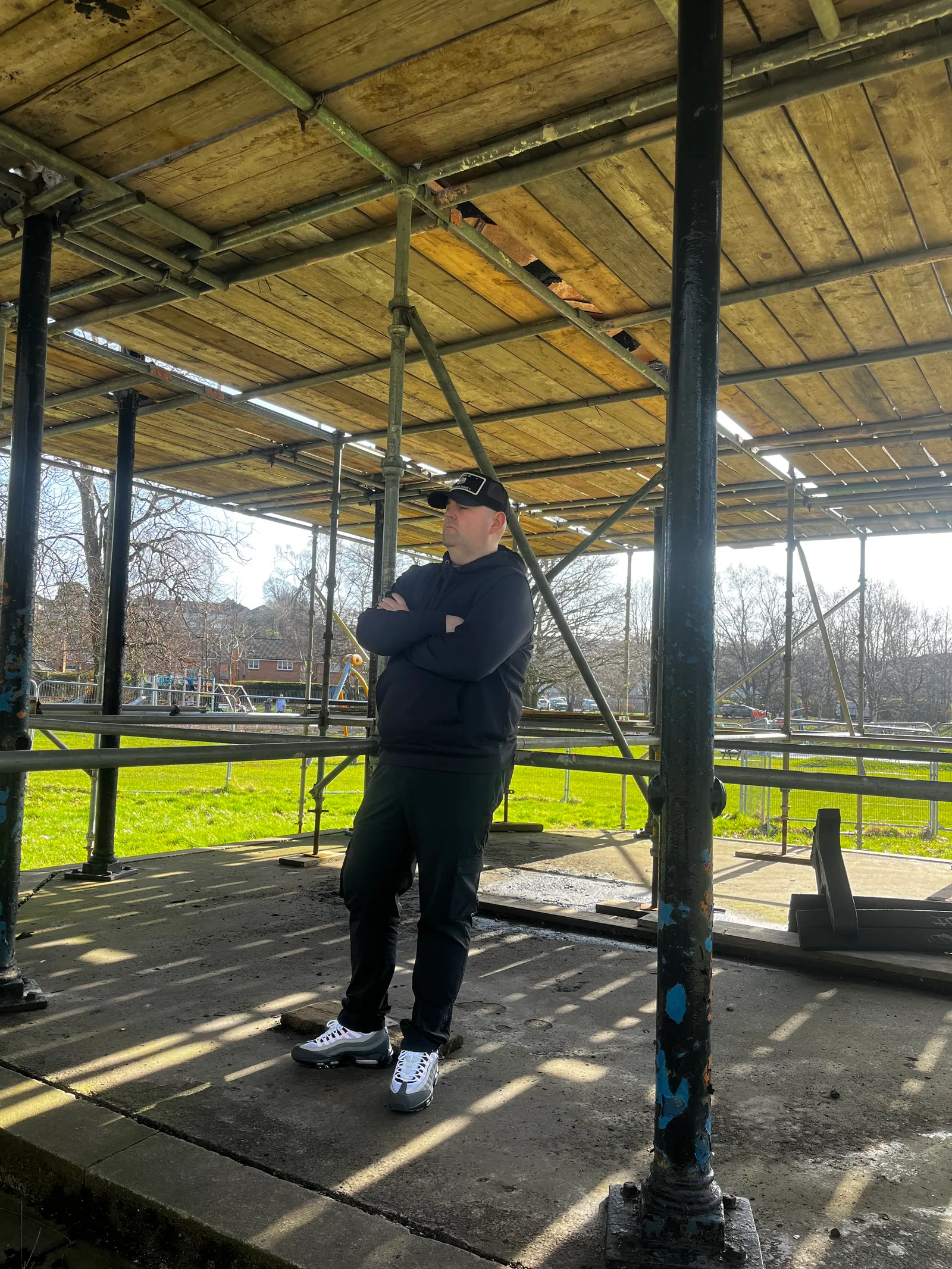 Macca standing under an outdoor shelter